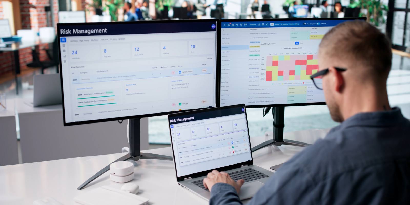A cybersecurity consultant reviewing risk management dashboards on multiple screens representing professional cybersecurity risk analysis