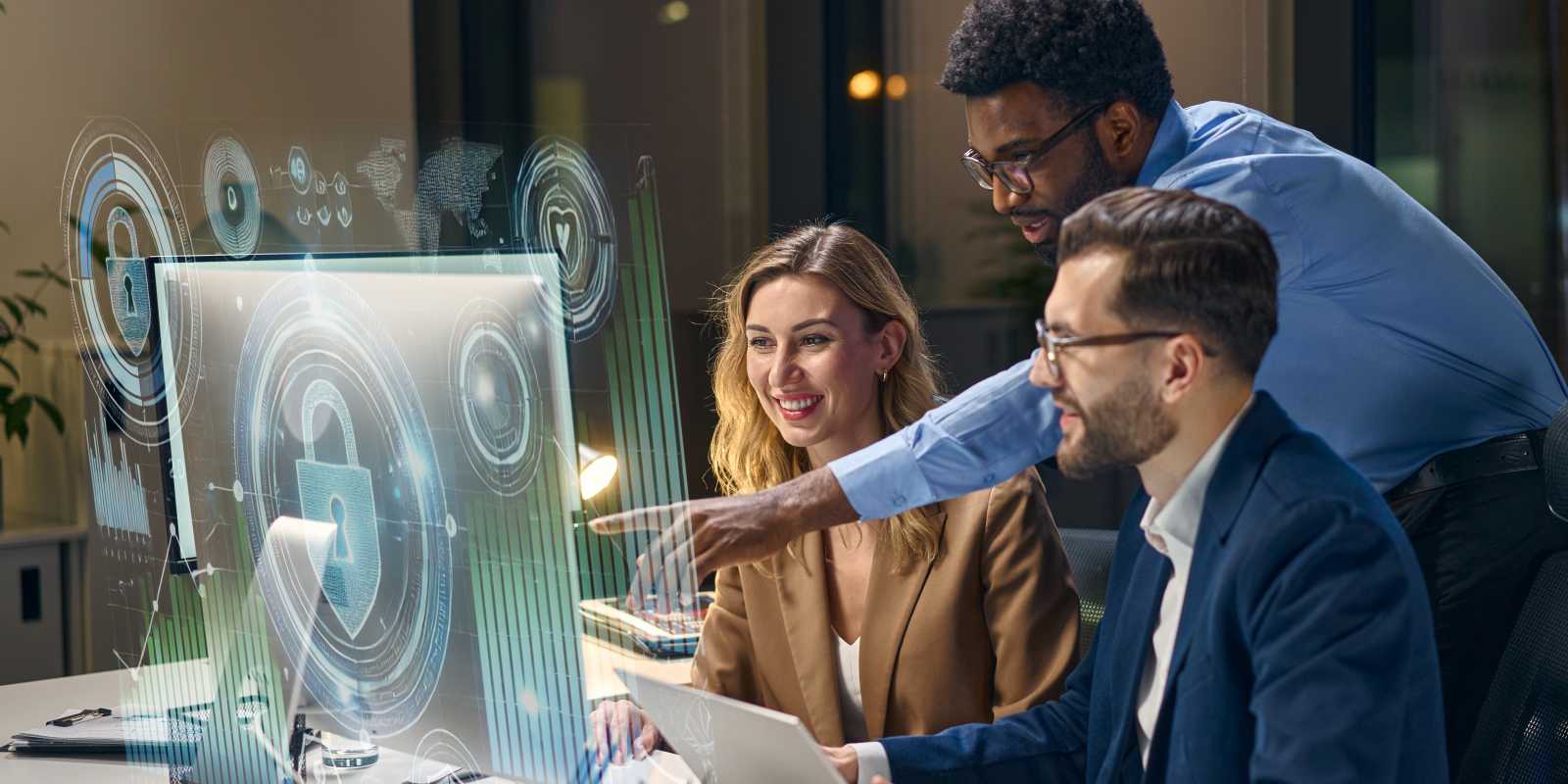 A diverse cybersecurity team collaborating around a monitor displaying digital security icons and padlock representing teamwork in cybersecurity operations