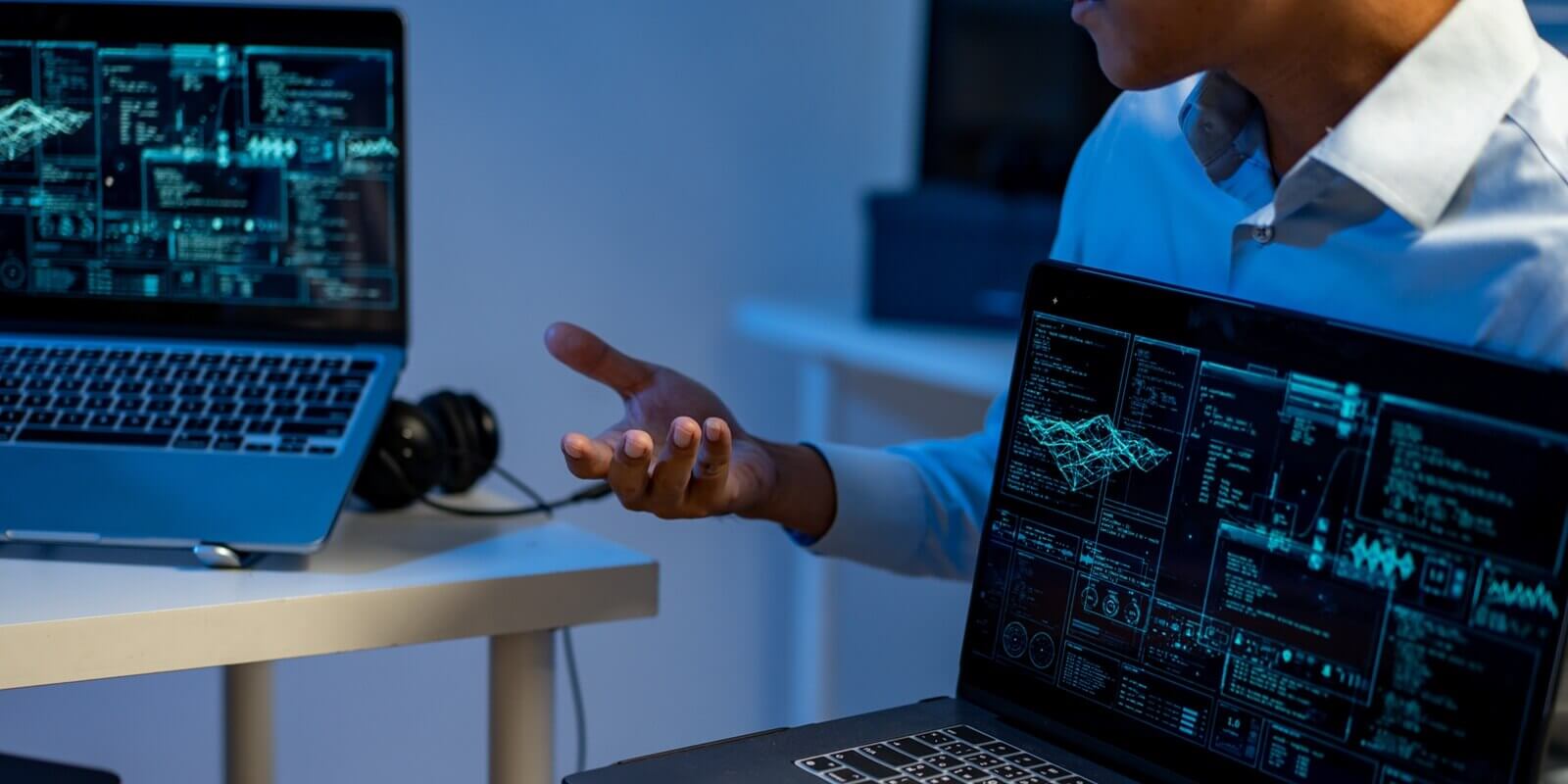 professionals discussing data analysis and cybersecurity on laptops with glowing dashboard screens in a modern office
