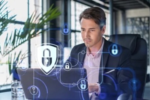 handsome businessman in suit at workplace working with laptop to defend customer cyber security