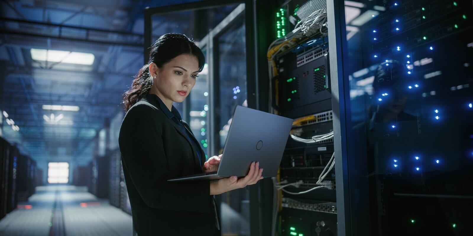 it engineer uses a laptop to check and monitor server equipment